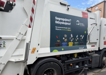 Śmieciarka w Poznaniu z edukacyjnymi naklejkami dotyczącymi segregacji odpadów i harmonogramu odbioru śmieci.