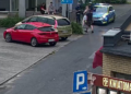 Policjant podczas kontroli drogowej zatrzymuje młodego kierującego hulajnogą elektryczną.