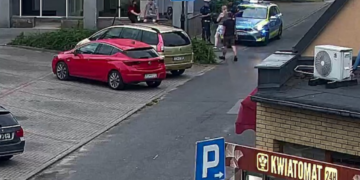 Policjant podczas kontroli drogowej zatrzymuje młodego kierującego hulajnogą elektryczną.